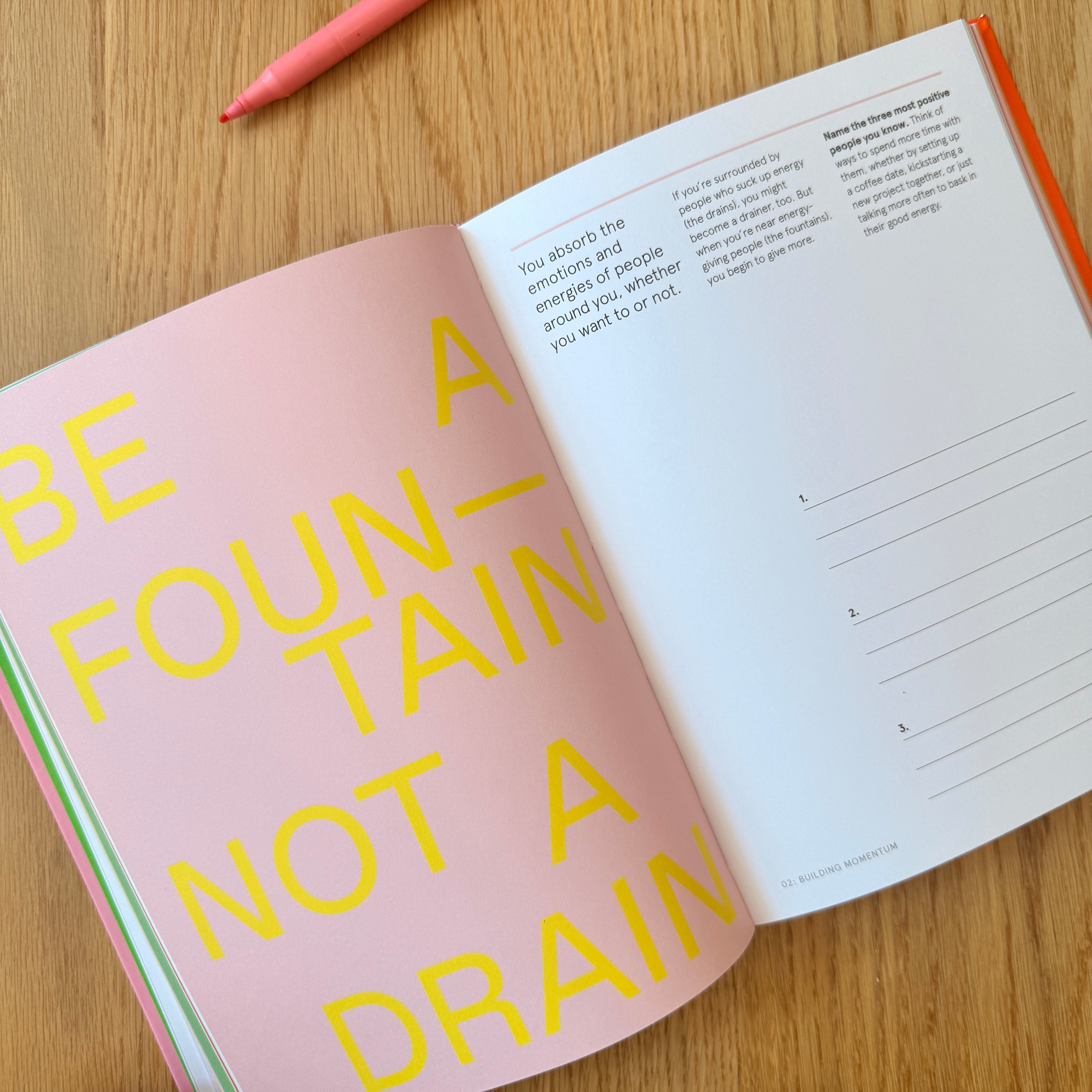 Open book with motivational text on a wooden surface