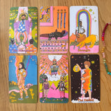 Set of colorful tarot cards on a wooden surface with a bracelet.