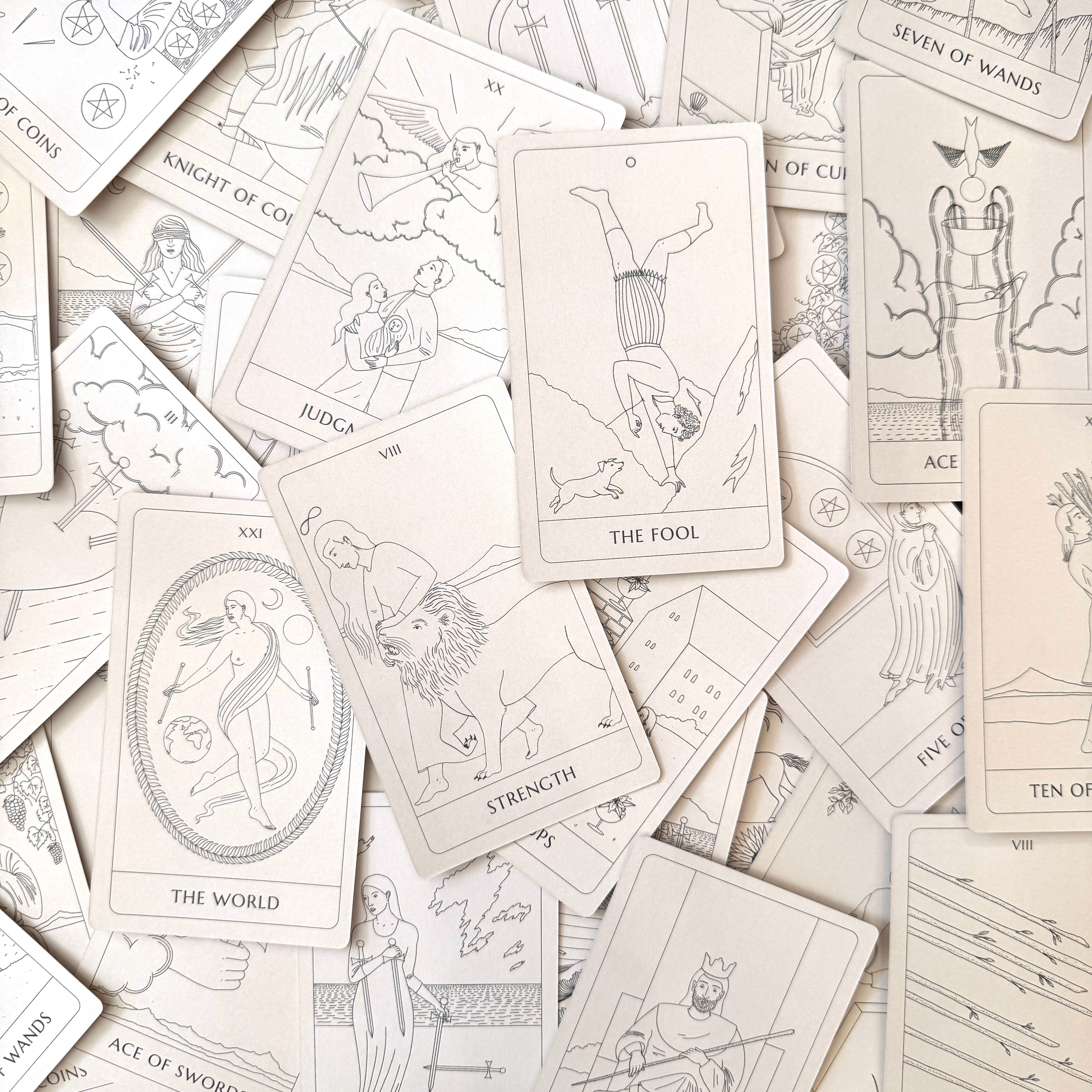 Collection of tarot cards with various illustrations on a light background