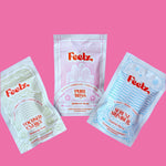 Three 'Feelz' product packages on a pink background