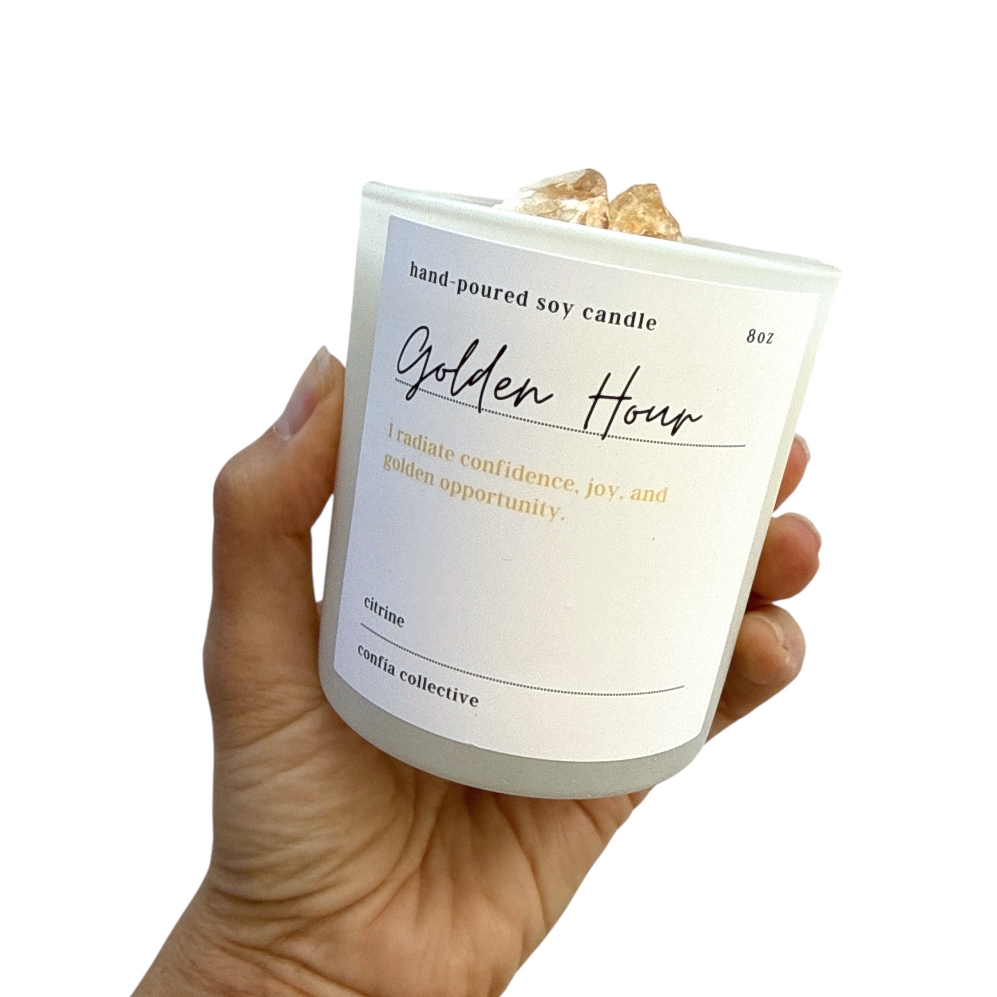 Hand holding a candle labeled 'Golden Hour' with a white background