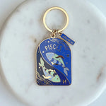 Keychain with Pisces design on a marble surface