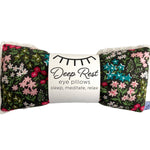 Floral patterned eye pillows with a label on a white background