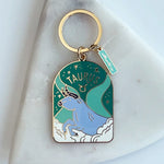 Green and blue Taurus keychain on a marble background
