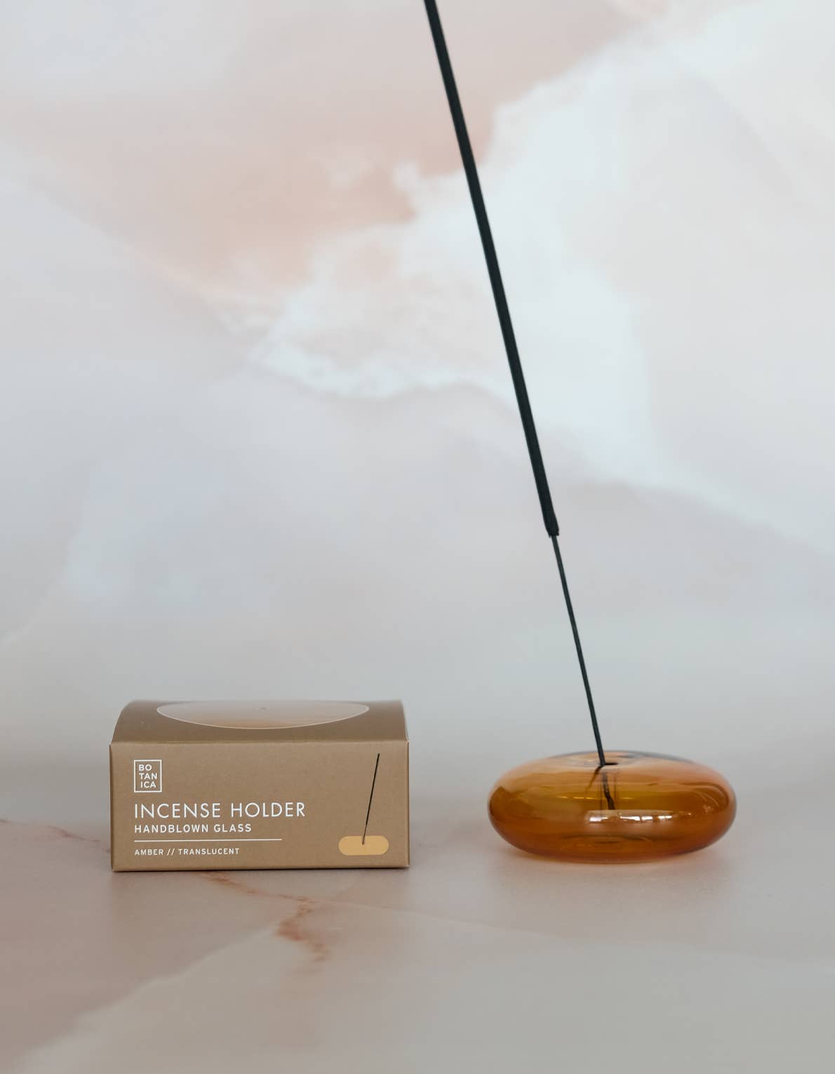 Wooden incense holder with a single stick of incense on a light background