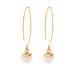 Gold earrings with pink stone drops on a white background