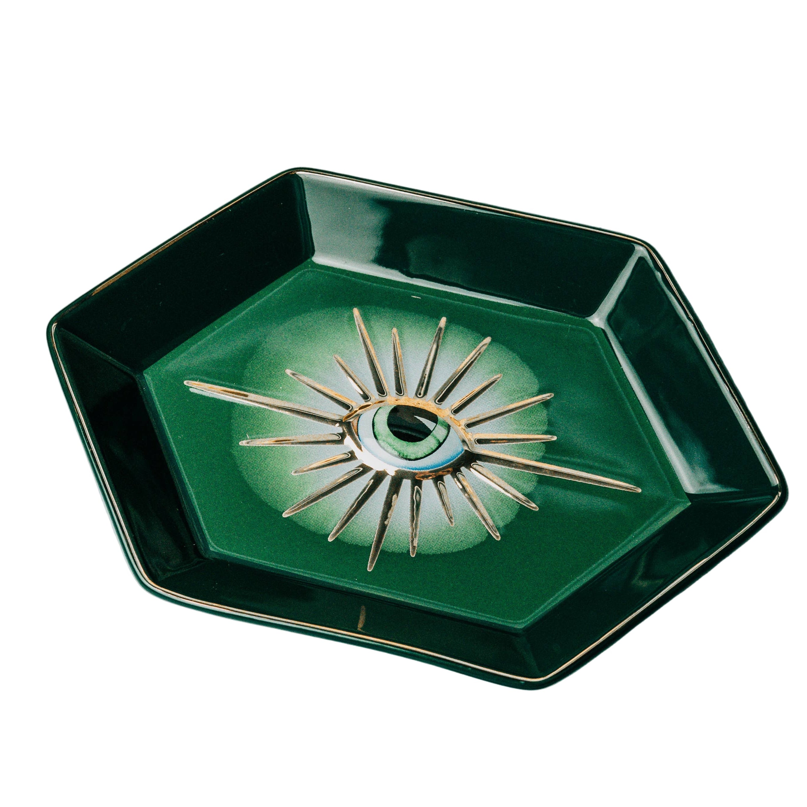 Decorative green dish with evil eye design on a white background