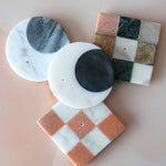 Set of marble incense holders with different patterns on a light pink background