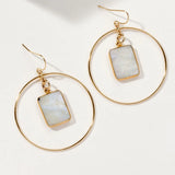 Gold hoop earrings with rectangular moonstone pendants in center, on a white background