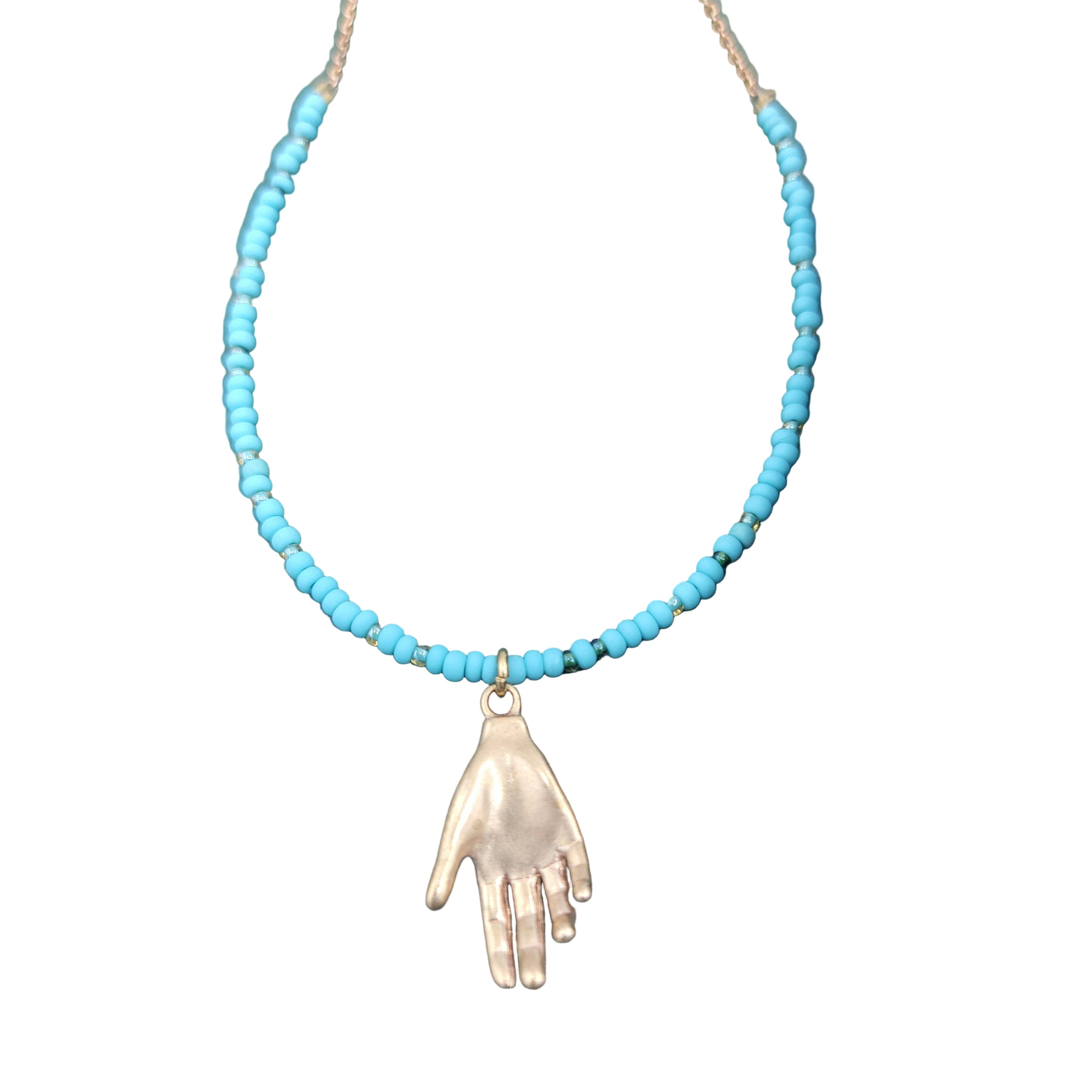 Necklace with turquoise beads and a hand pendant on a textured green surface.