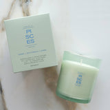 Green candle and packaging on a marble surface