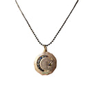 Necklace with a circular pendant featuring a moon design 