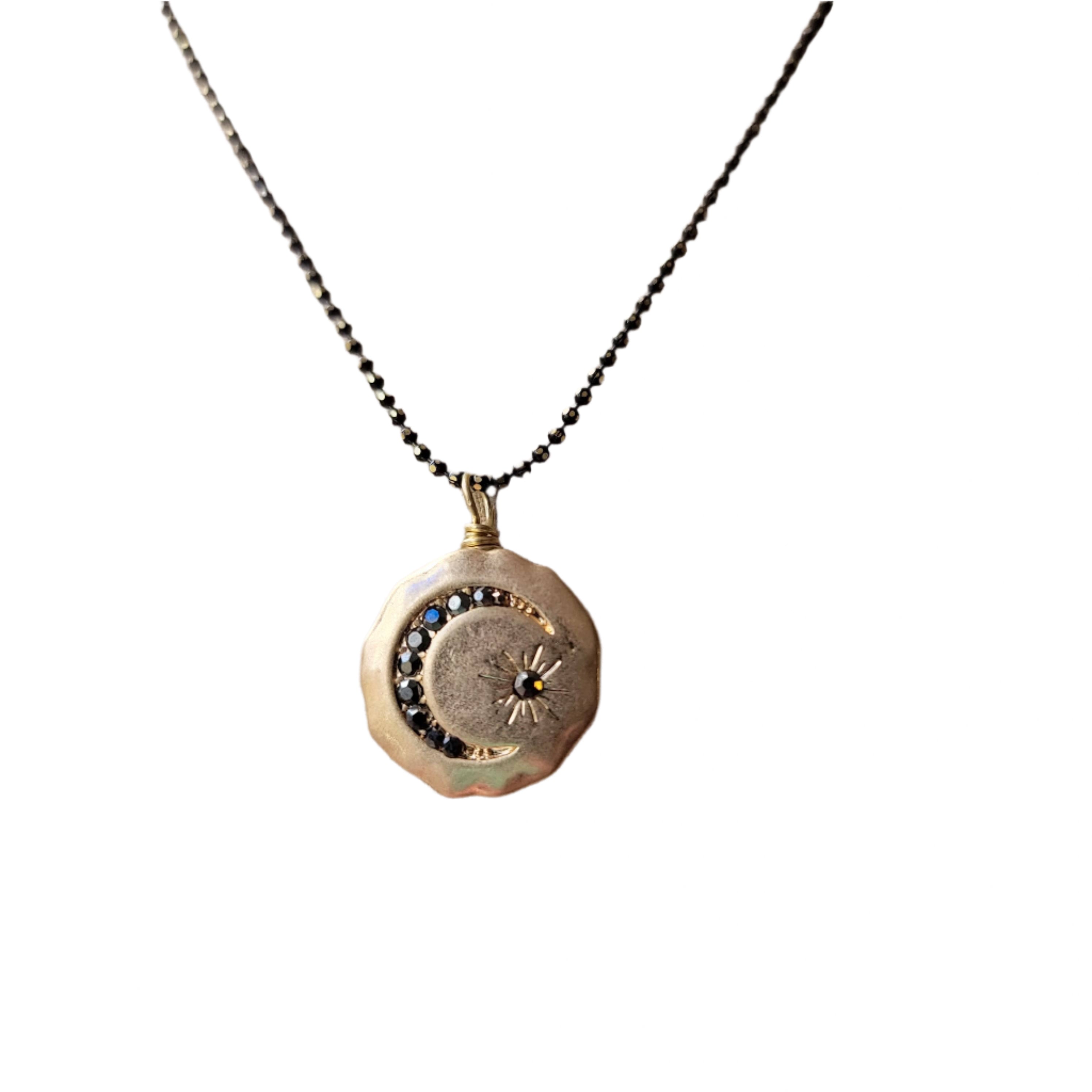Necklace with a circular pendant featuring a moon design 