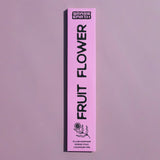 A tall, narrow pink box for Grass Earth Fruit Flower incense sticks, shown vertically against a matching dusty lavender background.