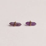 Amethyst crystal earrings on a light beige background