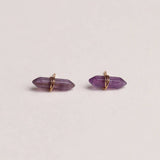 Amethyst crystal earrings on a light beige background