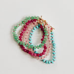 Set of colorful beaded bracelets on a light gray background