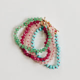 Set of colorful beaded bracelets on a light gray background