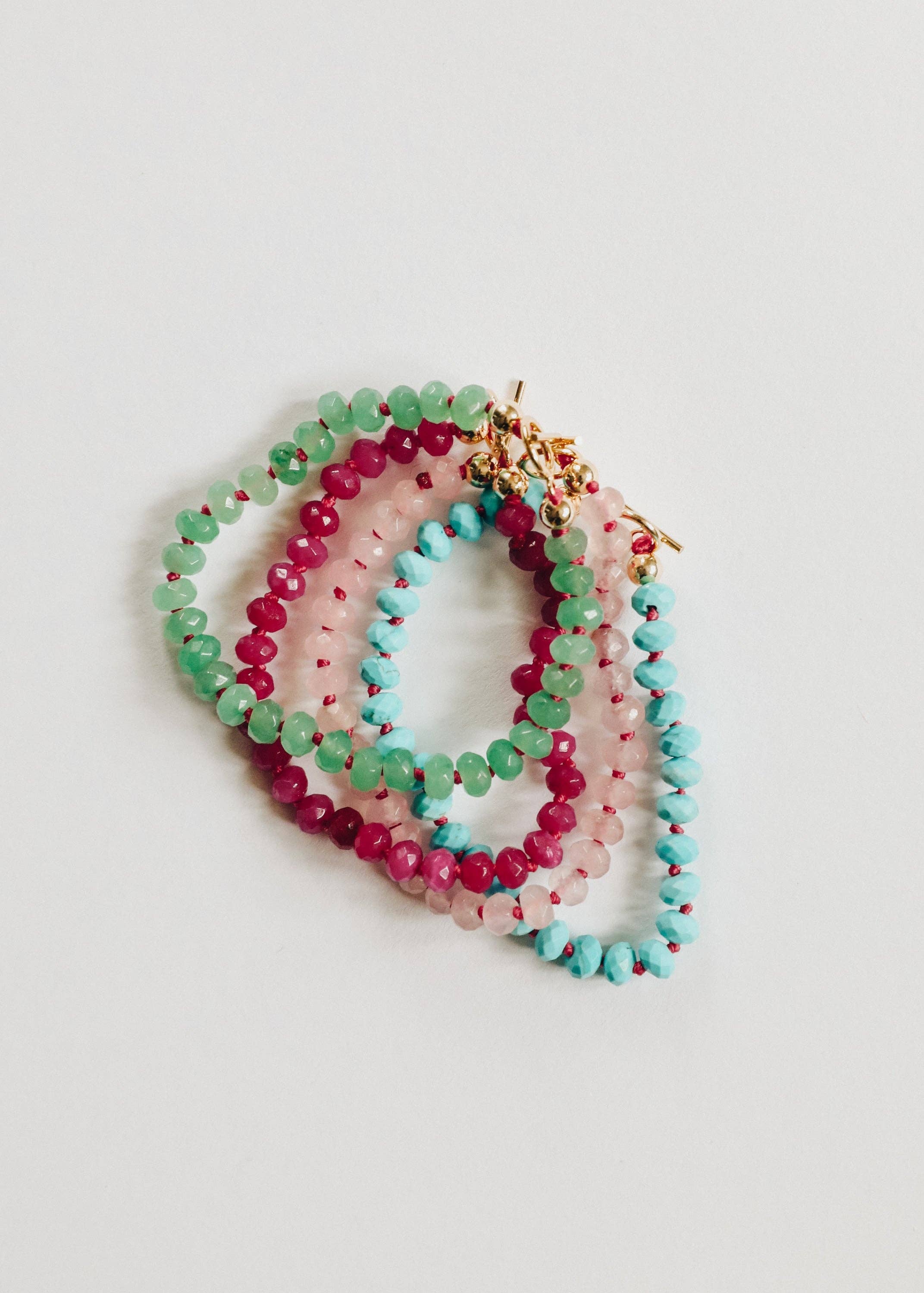 Set of colorful beaded bracelets on a light gray background