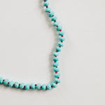 Turquoise beaded necklace on a light gray background