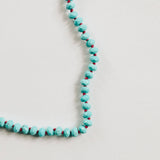Turquoise beaded necklace on a light gray background