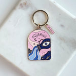 Aquarius zodiac keychain on a marble surface