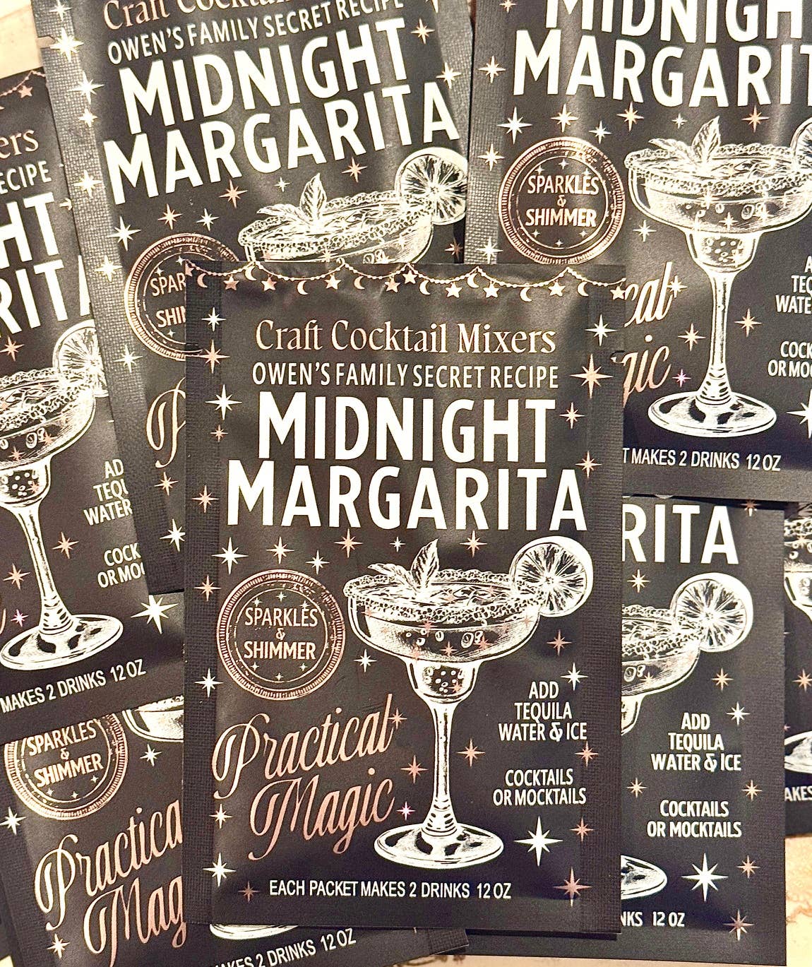 Packages of Craft Cocktail Mixers with 'Midnight Margarita' and 'Practical Magic' branding.