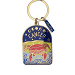 Keychain with Cancer zodiac design on a white surface