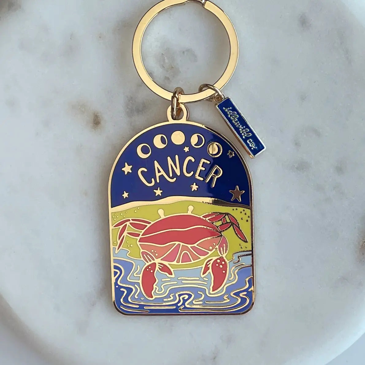 Keychain with Cancer zodiac design on a marble surface