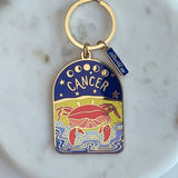 Keychain with Cancer zodiac design on a marble surface