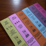 Set of colorful incense boxes with text and graphics on a wooden surface