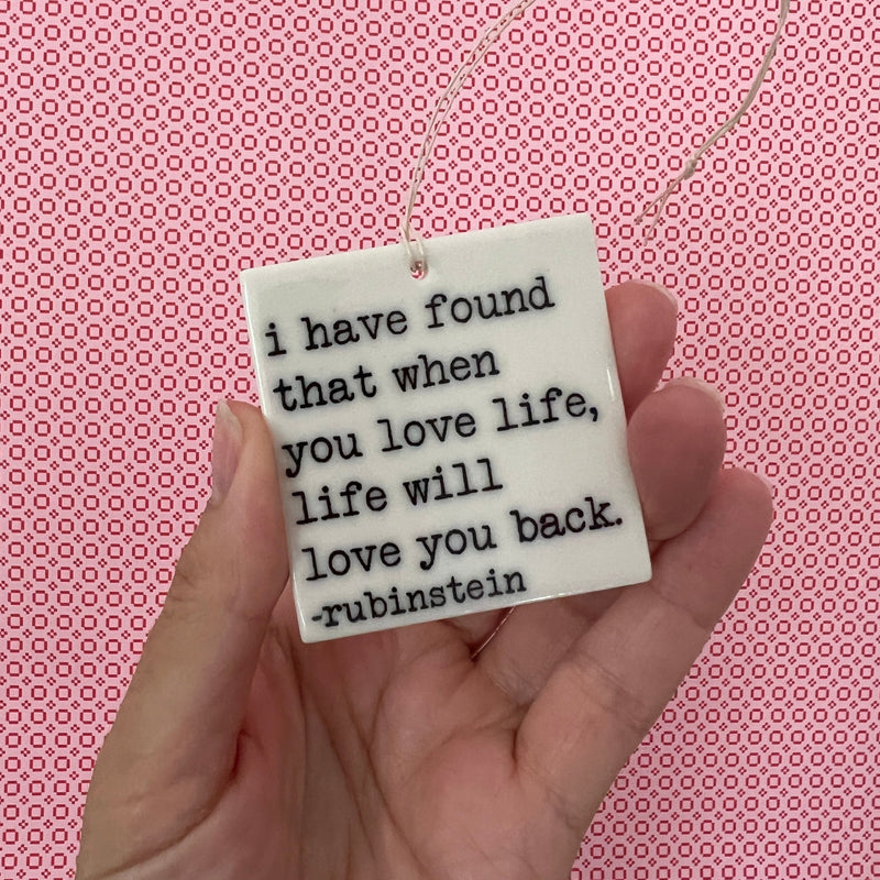 "I have found when you love life, life will love you back." - Rubinstein quote screen-printed porcelain plaques. 2 1/4"x 2 1/4"