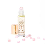 Love Essential Oil Roll On aromatherapy with rose quartz crystals.