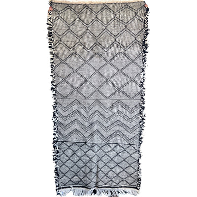 This incredible Moroccan hand-loomed wool rug has 3 sections of different patterns that all go together due to the black and cream wool being used.