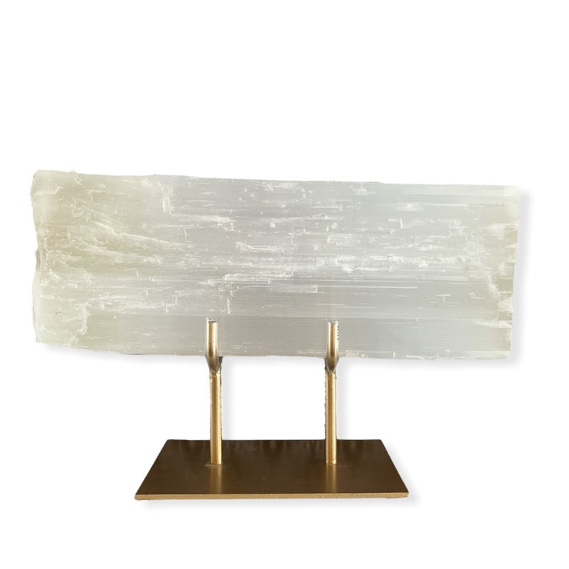 Selenite slab comes magnificently displayed on a gold stand.